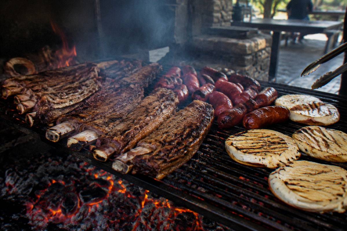 Beef ribs, chorizo and provoleta on a parrilla over wood embers