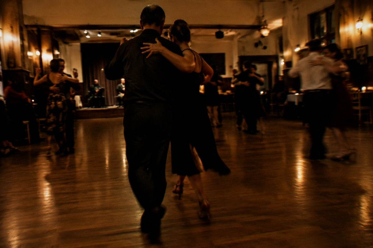 Couples dancing tango in a small Montevideo dance hall